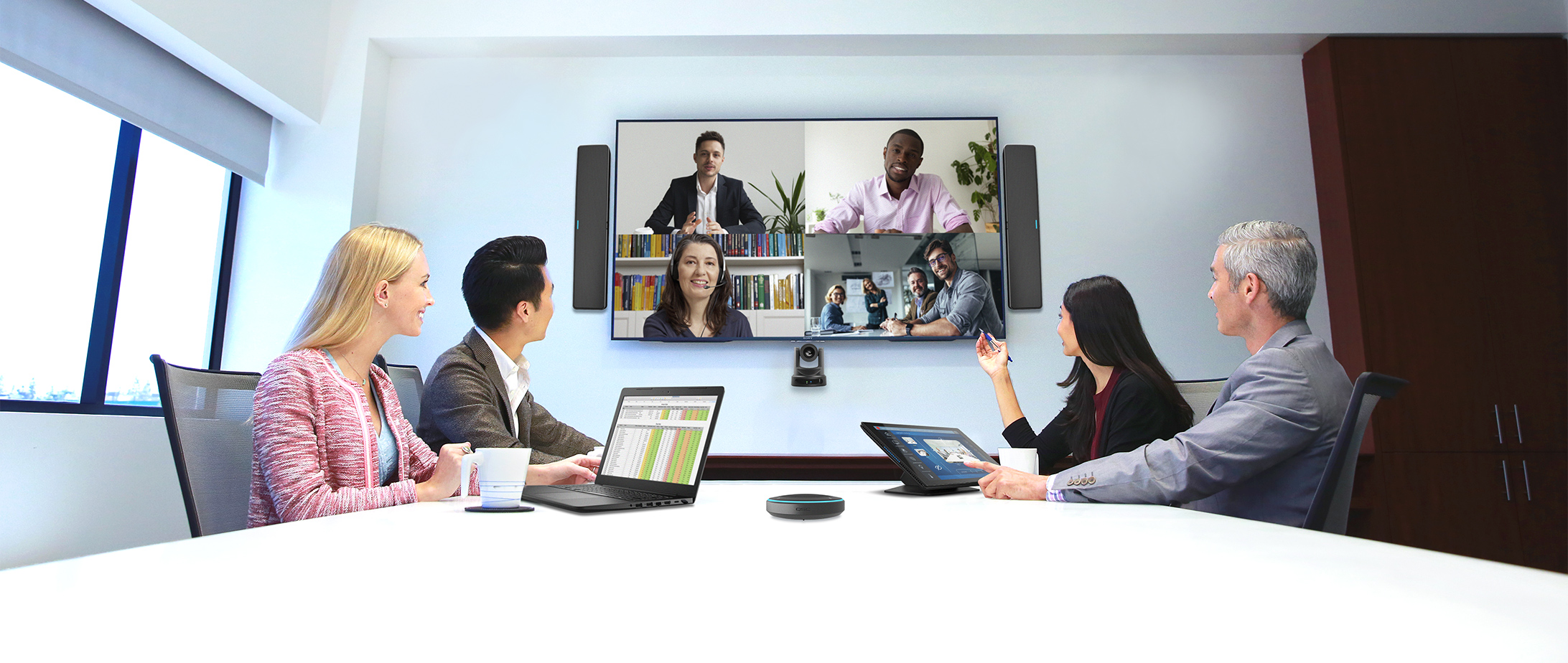 Office participating in a video conference call utilizing various Q-SYS products