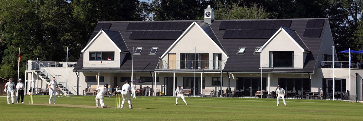 The Falkland Cricket Club with players practicing in the field out-front